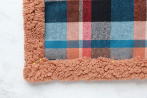 Fabric turned up and pinned with mitered. corners.