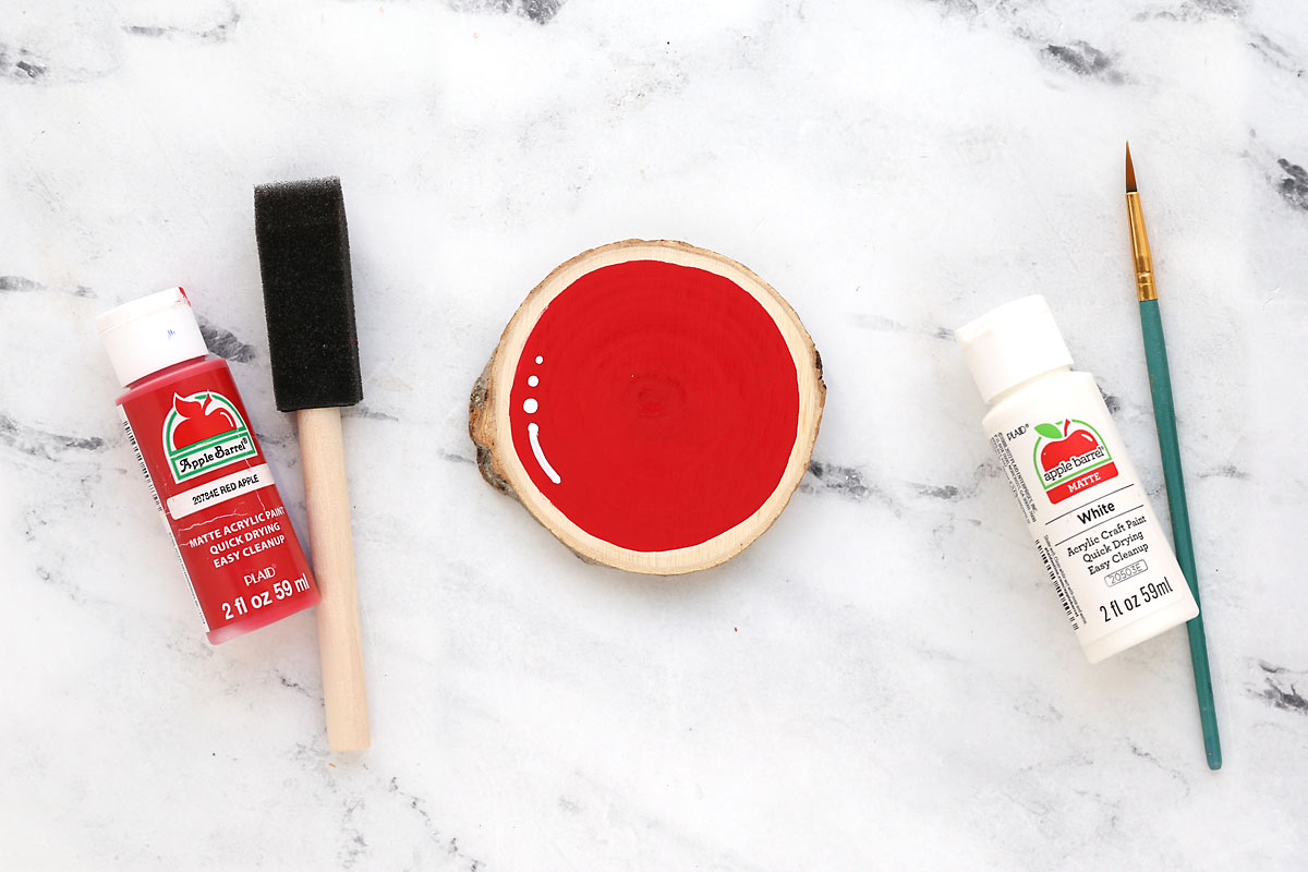 Paint the coaster red with a foam brush, add white dots with the end of a small brush.