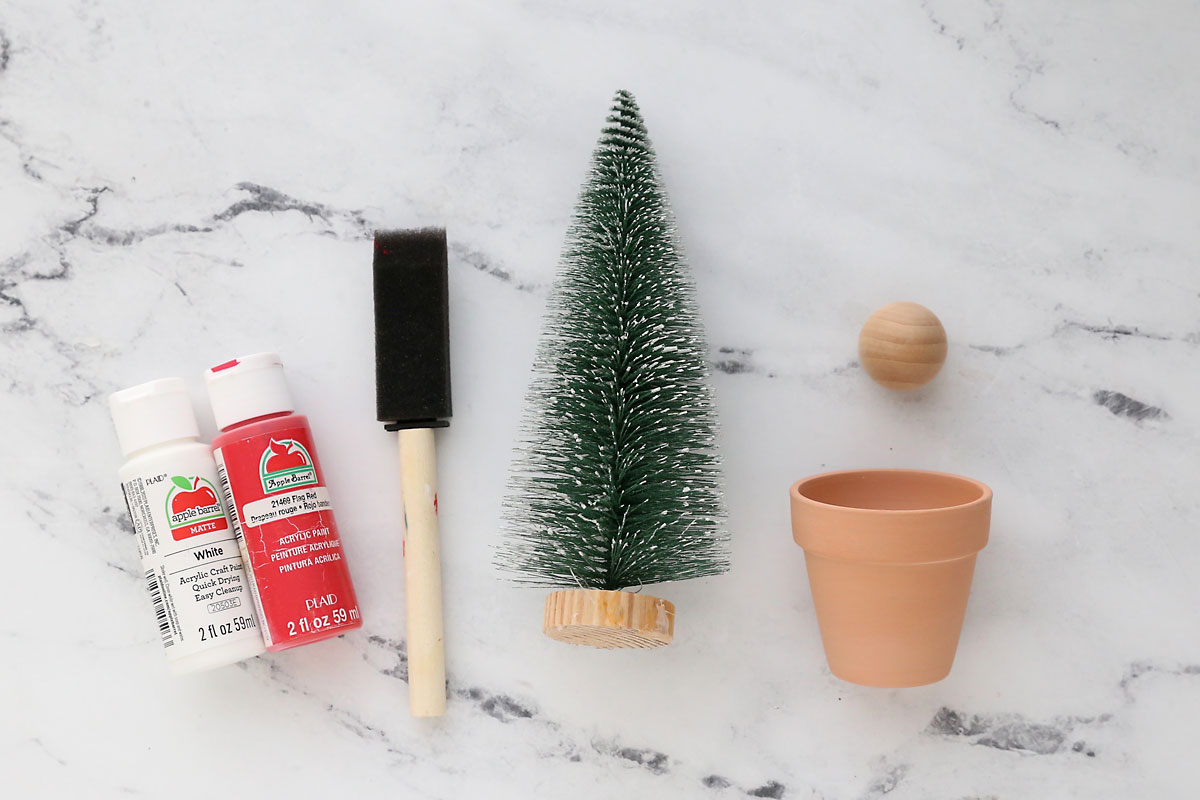 White and red paint, foam paintbrush, mini Christmas tree, small flower pot, wood knob.