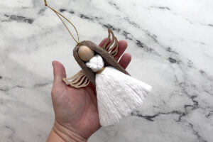 Finished macrame angel ornament.
