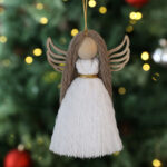 Macrame angel ornament on a Christmas tree.