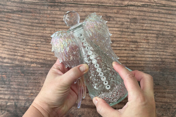 Holding wings to back of bottle to adhere.