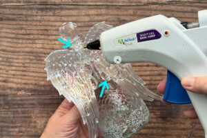 Adding more hot glue where wings touch bottle.