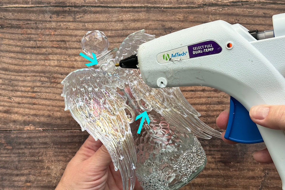Adding more hot glue where wings touch bottle.