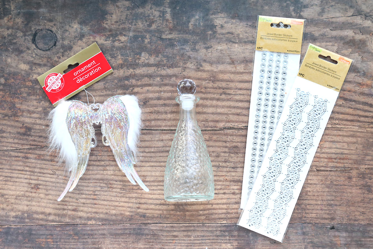 Angel wing ornament, glass bottle, gem stickers.