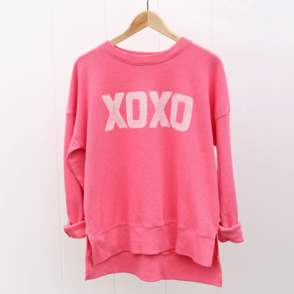 Pink sweatshirt with XOXO stamped on the front.