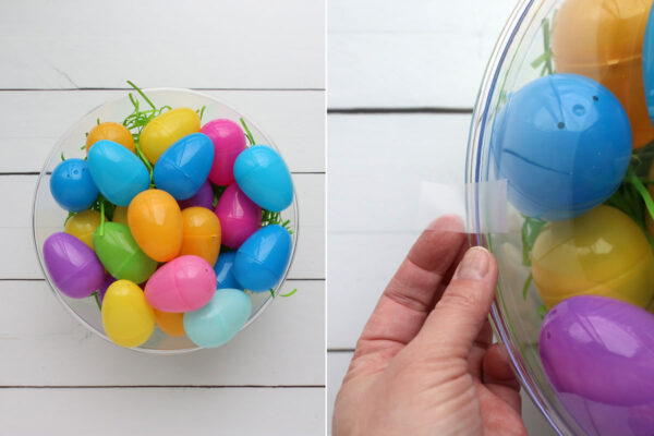 Plastic bowl filled with Easter grass and eggs; a second plastic bowl taped on top.