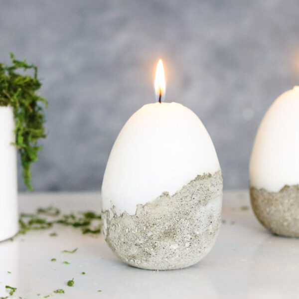 Egg shaped candle with concrete base.
