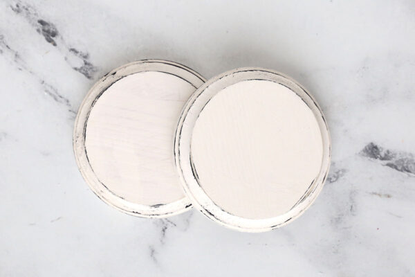 Wood rounds painted white with black distressing on the edges.