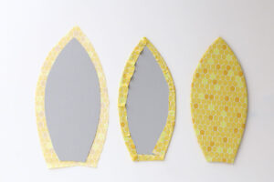 Fabric cut just larger than the petal template, fabric wrapped to the back of the template and glued to secure.