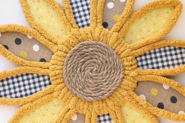 Rope covered circle glued onto wreath to look like sunflower center.