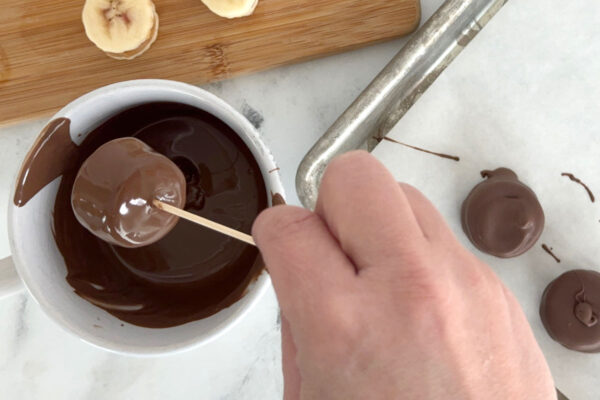 Tapping off excess chocolate.