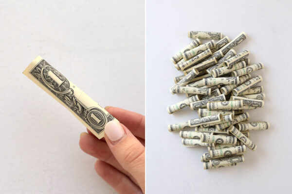 Rolled dollar bills secured with small clear hair band.