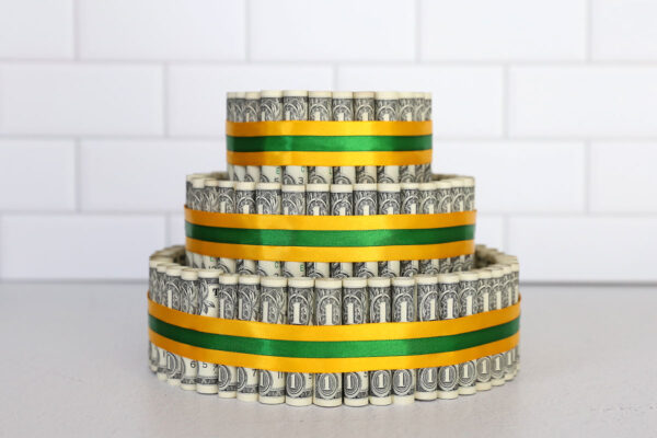 All three tiers surrounded with rolled money and secured with ribbon.
