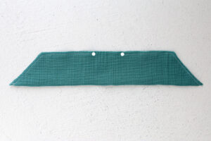 Tail piece folded in half lengthwise and sewn, with opening left between dot marking on pattern.