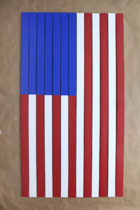 Yardsticks put together to make vertical flag, with blue at the top left.