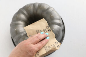 Using sandpaper on the bundt pan.
