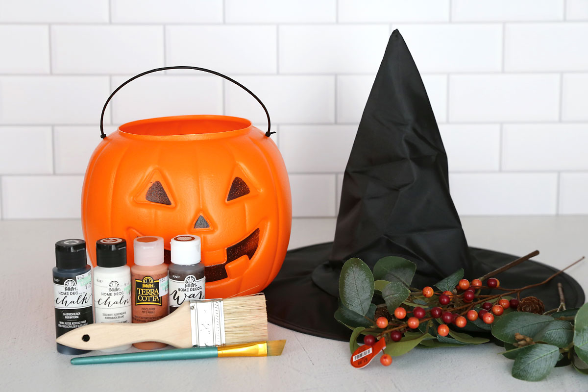 Supplies: plastic pumpkin, witch hat, paint, paintbrushes, faux leaves and berries.