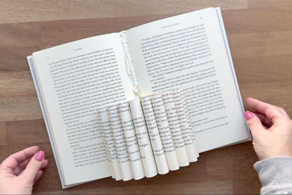 Book with rolled pages to create vase for flowers.