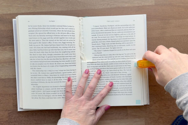Adding adhesive in corners of pages.