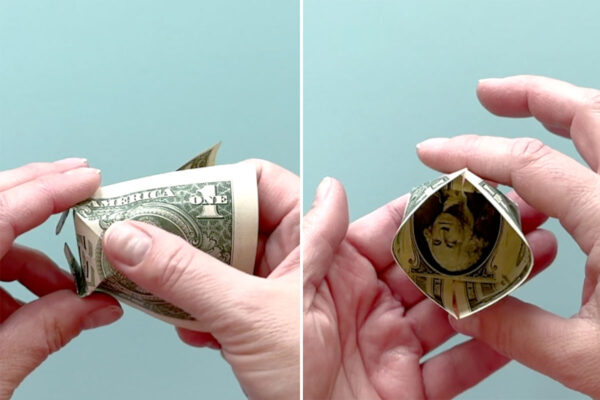Folding dollar bill into cup shape.