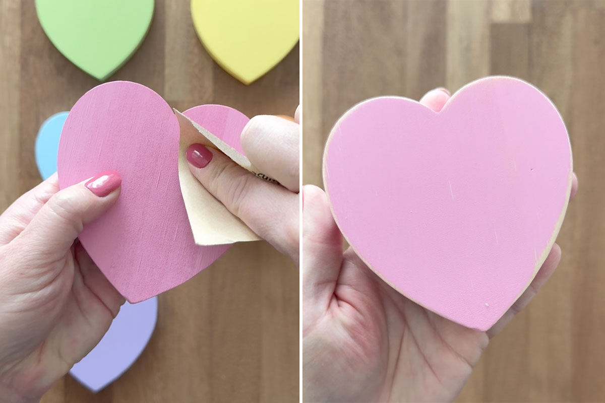 Using sandpaper to distress wooden heart.