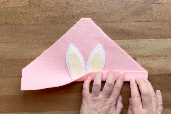 Folding the bottom edge of hat piece up one inch and gluing.