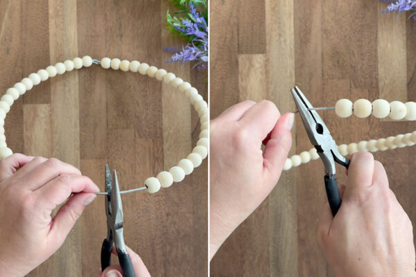 Using pliers to bend bottom of wreath in toward center.