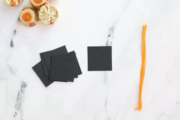 Black cardstock cut into 1.5 inch squares, yellow embroider floss cut into 5 inch lengths.