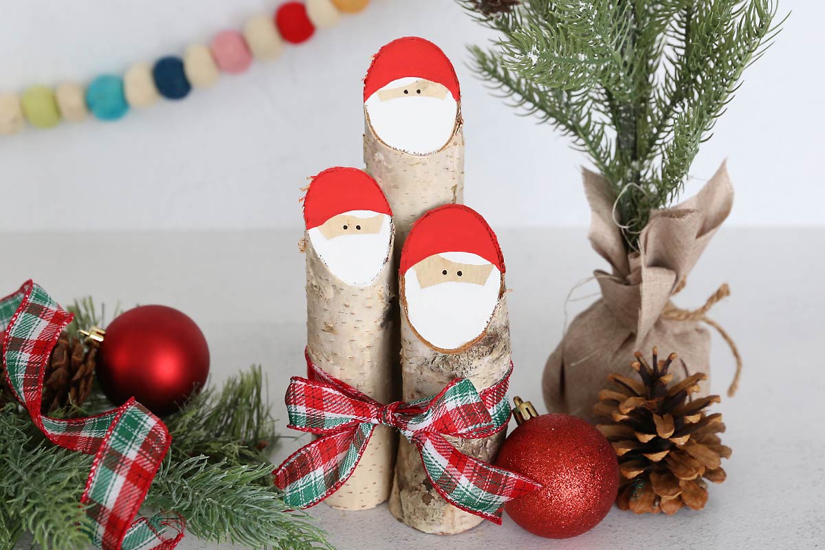 Three log Santas tied with a ribbon.