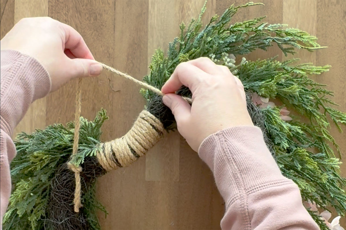 Tying twine in the back of the wreath for a hanger.