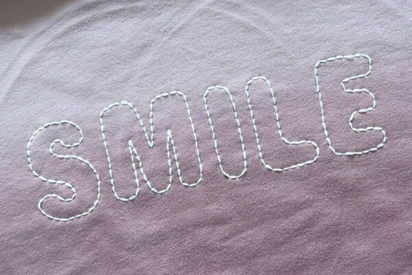 All letters outlined in embroidery.