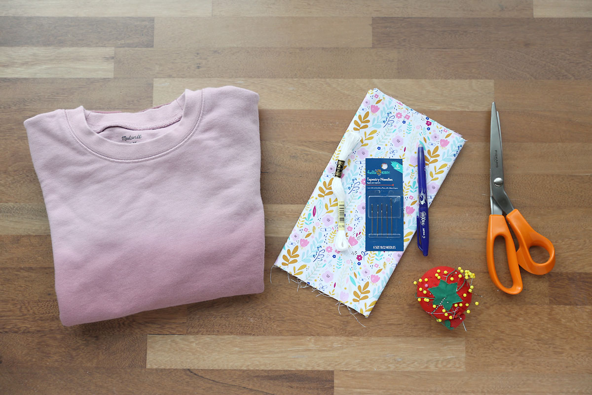 Sweatshirt, cotton fabric, needles, embroidery thread, pins, pinking shears, fabric marker.
