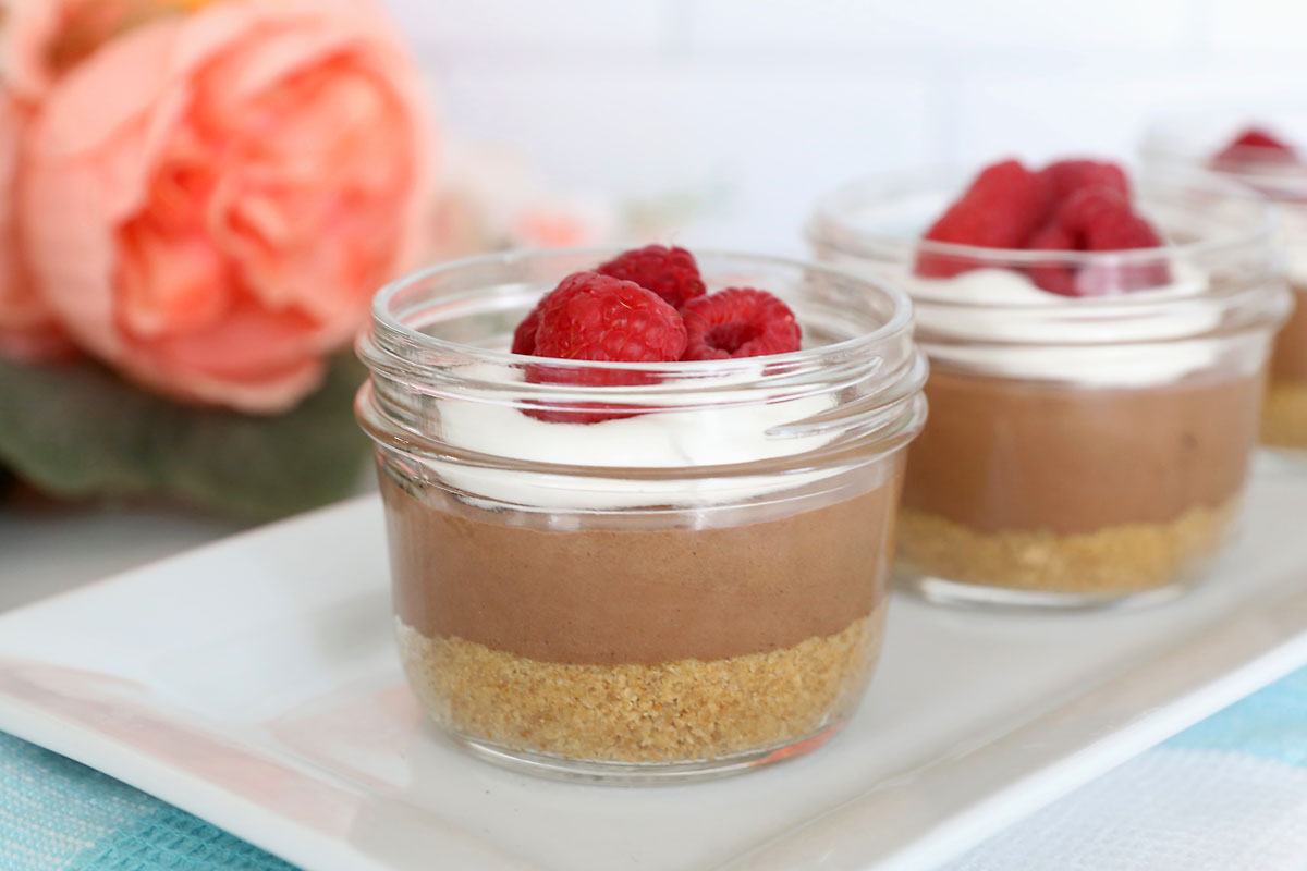 Chocolate cream pie cup with raspberries in top.