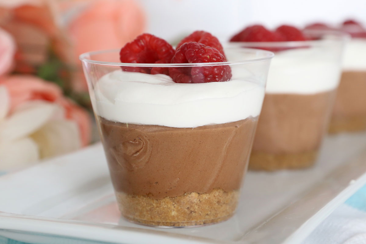 Chocolate cream pie cup with raspberries in top.