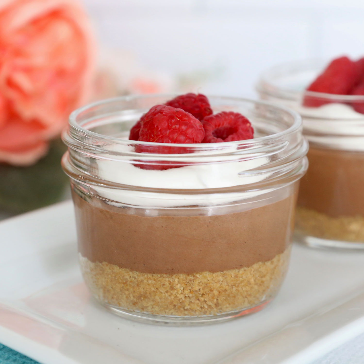 Chocolate cream pie cup with raspberries in top.