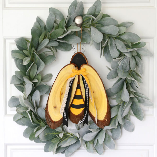 Bee made from wood slices on a wreath.