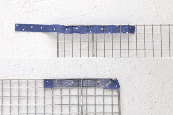 Weaving blue strip in and out of cooling rack; folding over and gluing.