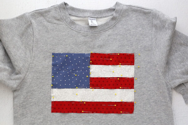 Fabric pinned to sweatshirt in flag design.