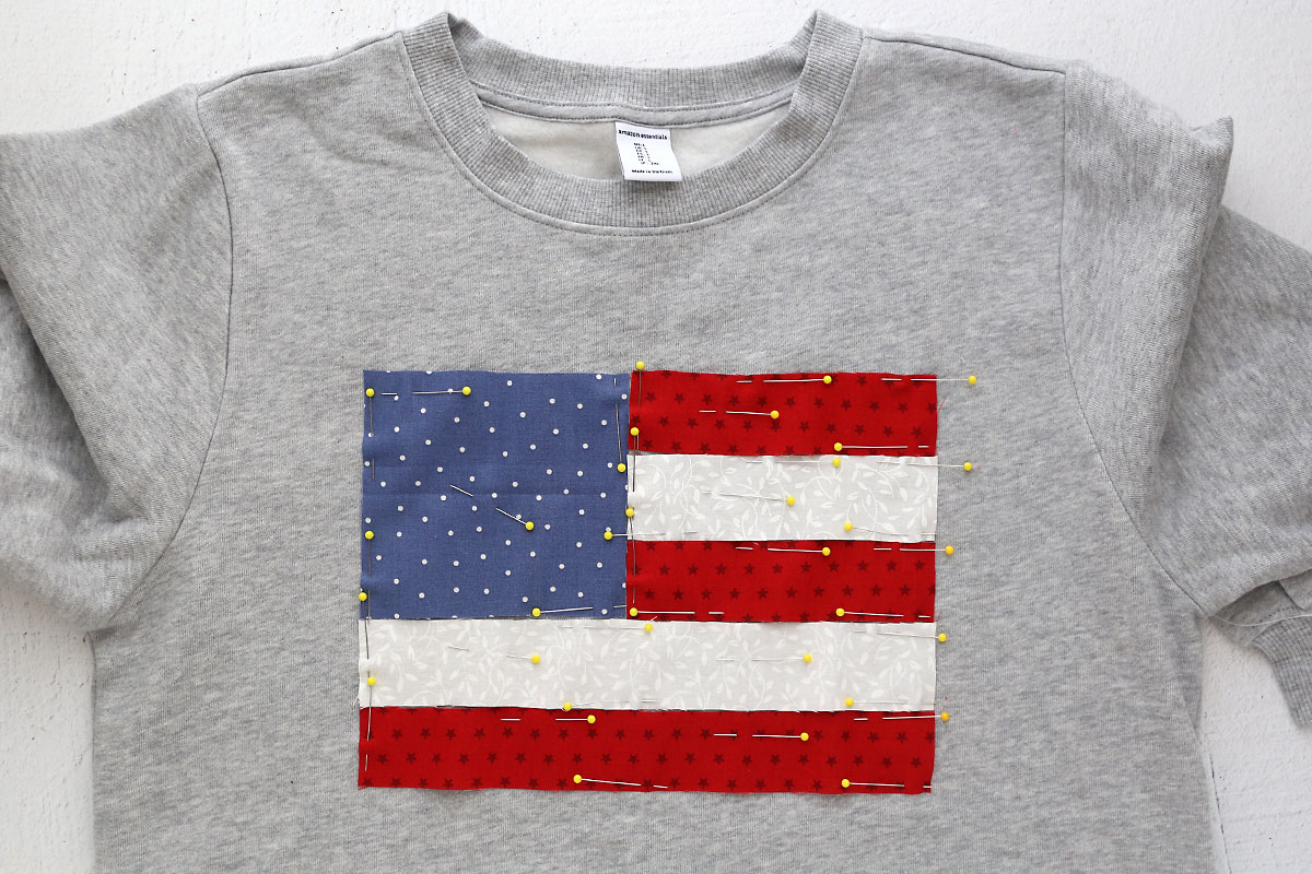 Fabric pinned to sweatshirt in flag design.