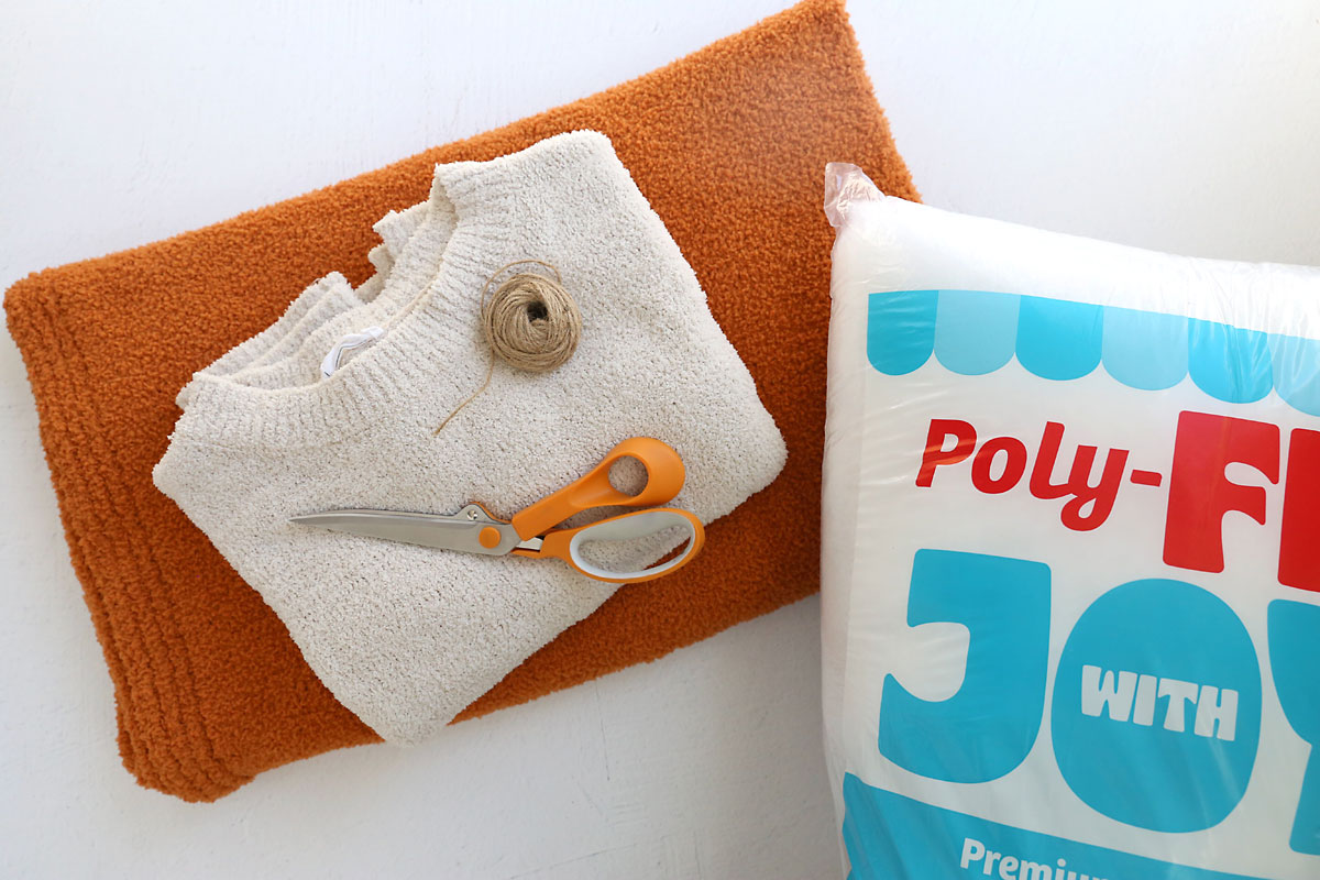 Blanket, sweater, scissors, twine, poly-fill.